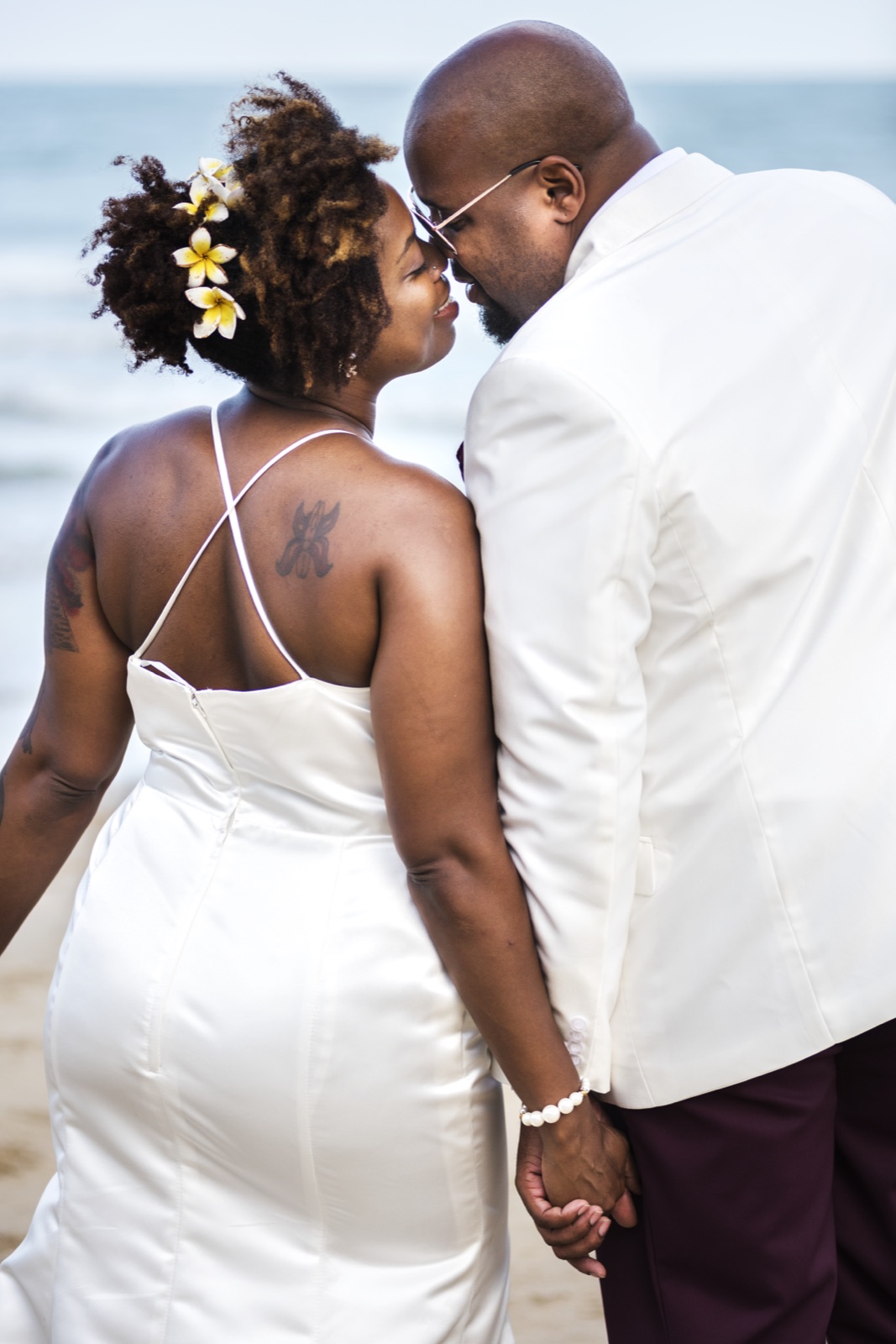 African American couple in white at their beach wedding ceremony